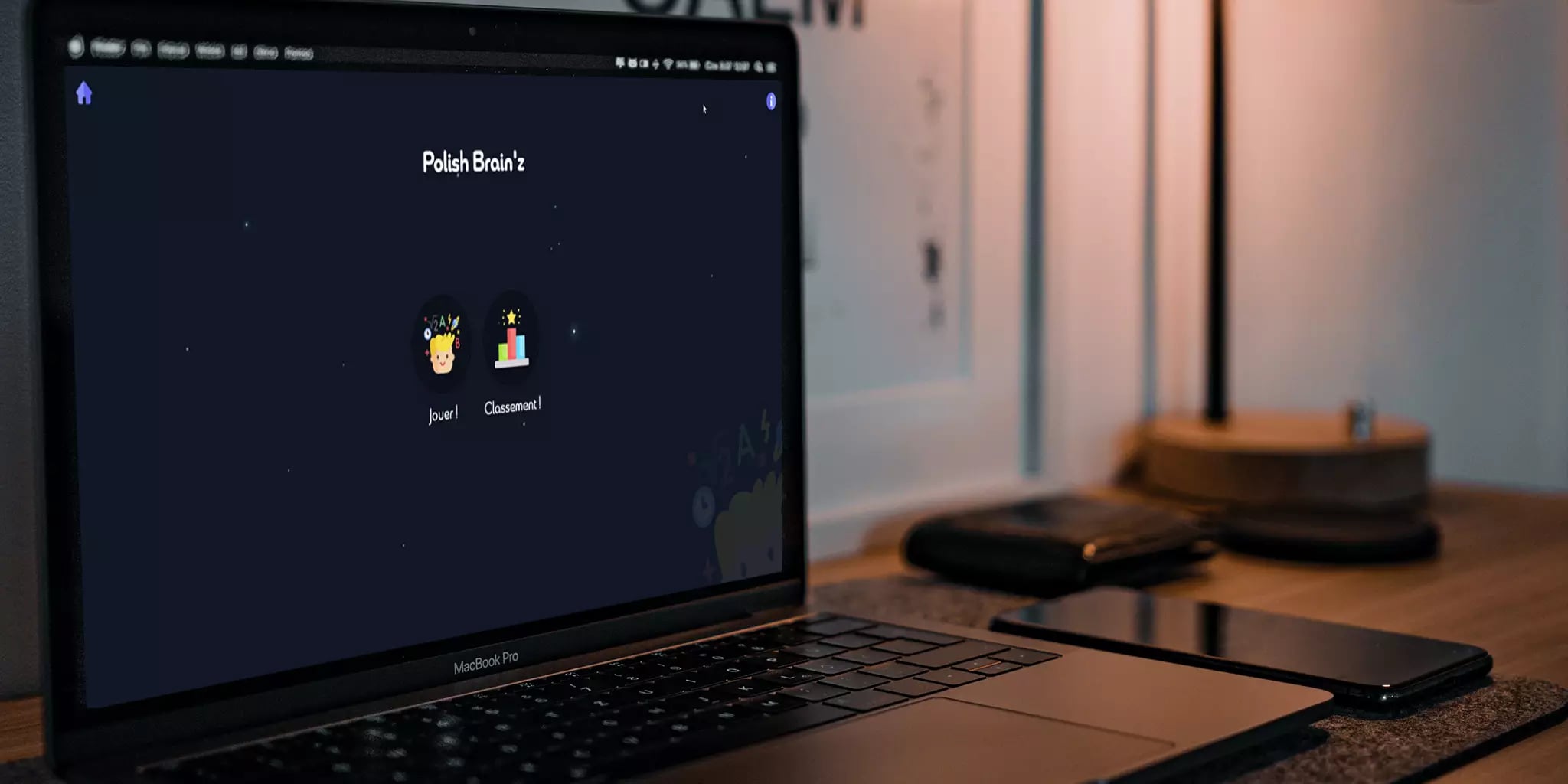 A modern workspace with a laptop displaying a webpage labeled 'Polish Brain't', a smartphone, and a desk lamp in the background